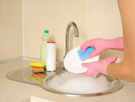 Womenï¿½s hands washing dish in the kitchenの写真素材