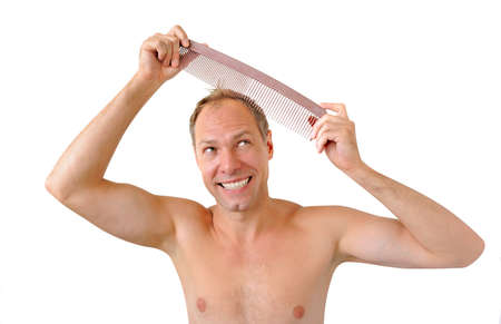 Smiling man hand holding comb on the headの写真素材