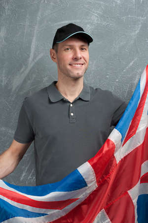 Smiling man in gray against background of the British flagの写真素材