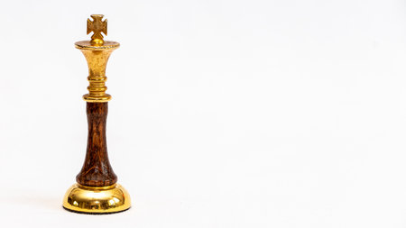 A golden King chess piece on a white backgroundの写真素材