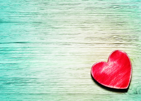 Decorative wooden red heart on blue wooden background
