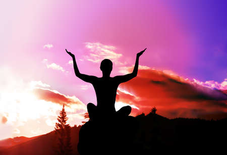 Yoga and meditation. Silhouette of girl in mountains.の写真素材