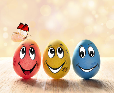 Easter eggs with smile and butterfly on blurred background