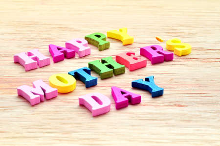 Happy Mothers Day colorful letters spelling greeting on rustic wood tableの写真素材