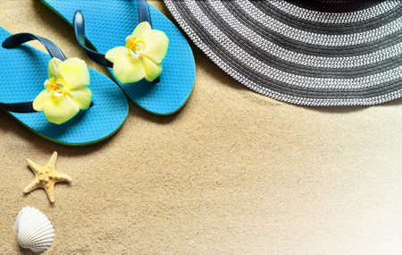 Flip Flops in the sand with starfish and orchid flowers. Summertime on beach concept. Summer beach.の写真素材