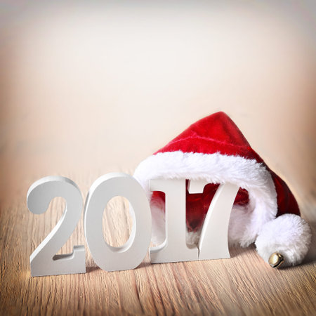 santa fur cap on a rustic wooden background with figures 2017