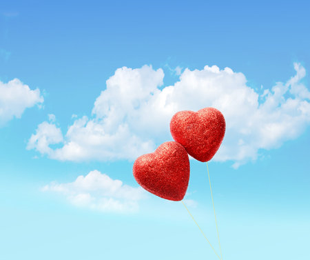 Greeting card for Valentine's Day , with two red hearts on sky backgroundの写真素材