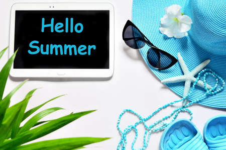 Tablet with blank screen on white surface with beach items, top view.の写真素材