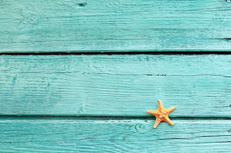 Summer sea background. Starfish on blue wooden background.の写真素材
