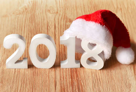 santa fur cap on a rustic wooden background with figures 2018の写真素材