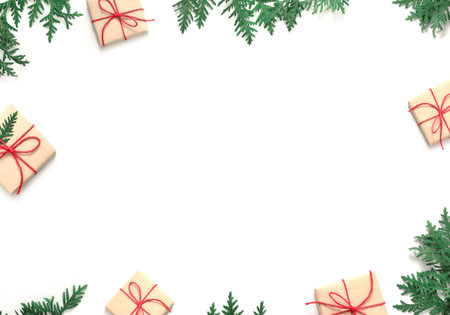 Christmas gift boxe and fir tree branch on white background. Top view with copy space.