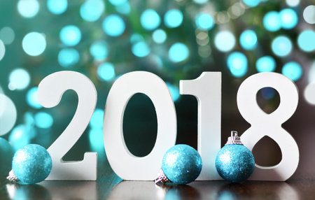 Wooden numbers forming the number 2018, For the new year 2018 on a glitter blurred background