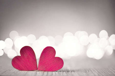 Hearts on a wooden table and background is a bokeh. valentines day concept.の写真素材
