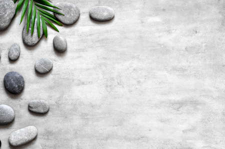 Grey spa background, spa concept, palm leaves and grey stones, top viewの写真素材