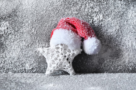 Christmas decor star with santa hat. Gray background.