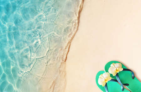 Flip flops on a sandy ocean beach.の写真素材