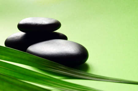 Stones for spa and green leaves on green backgroundの写真素材