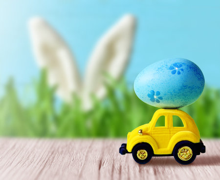 Retro toy car with Easter egg on the roof. on spring background Easter concept. Happy Easter.