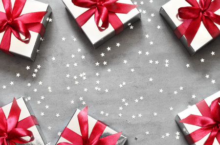Gift boxes with red ribbon on grey background with star. Top view.