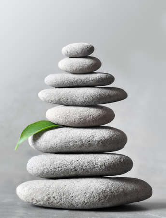 Stack of grey massage stones on grey background. Spa concept.の写真素材