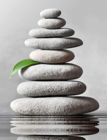 Stack of grey massage stones on grey background. Spa concept.の写真素材