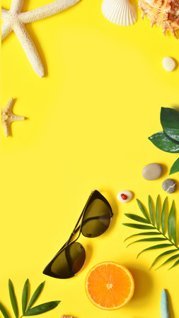 Summer background. Palm leaf, orange, starfish and seashell on yellow background. Travel. Copy...