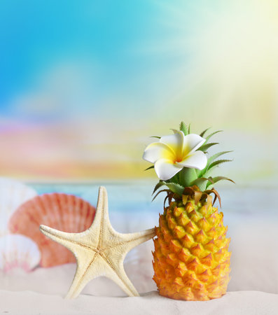 Pineapple with flower and seashells in the beach. Summer beach concept.