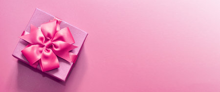 Holiday concept banner with hand made gift box, bow on a purple background with space for text