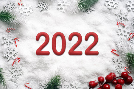 Fir branches with Christmas decorations on white background. 2022.