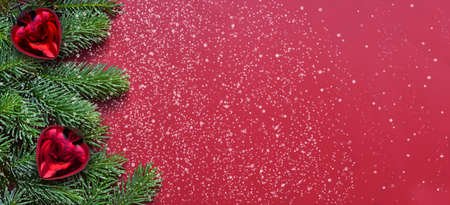 Red background with fir branches, lights and Christmas ball. Christmas decoration.の写真素材