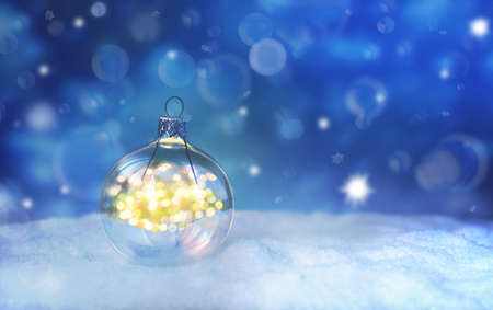 Beautiful blue Christmas ball with lights on snow and winter background.の写真素材