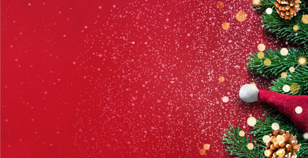 Red background with fir branches and Santa hat. Christmas decoration. Holiday concept.の写真素材