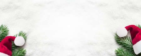 Santa hat with fir branch on snow. Christmas background.の写真素材