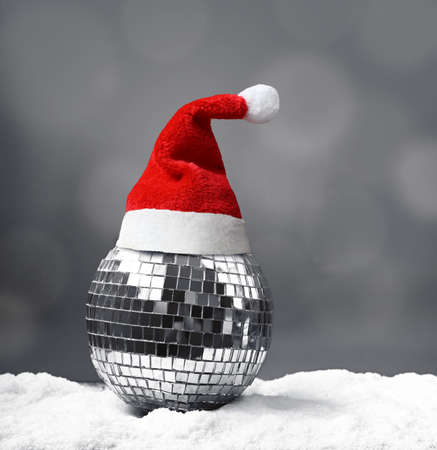 Beautiful mirrored Christmas ball on snow on gray background.の写真素材