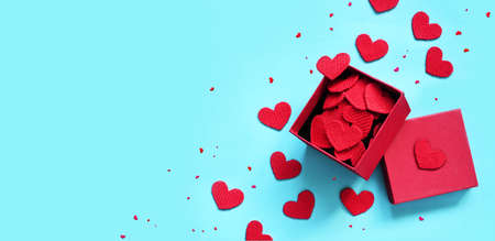 Open gift box and knitted hearts on blue background, top view. Valentines day greeting card. Flat lay style.の写真素材