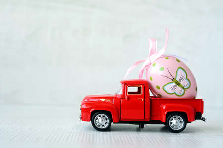 One Easter egg on a small car on a gray background. copyspace. Easter card.の写真素材