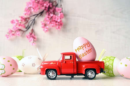 One Easter egg on a small car on a light background and blooming branch. copyspace. Easter card.の写真素材