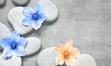 Spa stones and blue flowers on the gray background. spa concept.の写真素材
