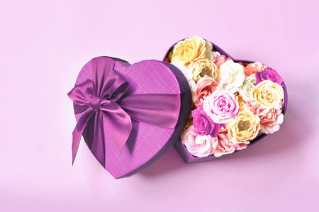 Heart shape gift box and bouquet. Flowers a gift in the shape of a heart. Roses in a box heart on pink backgroundの写真素材