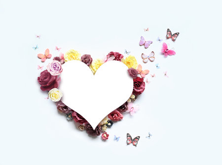 Happy mothers and Valentines day. Bouquet of colorful assorted roses in heart shape and butterfly on white background.の写真素材