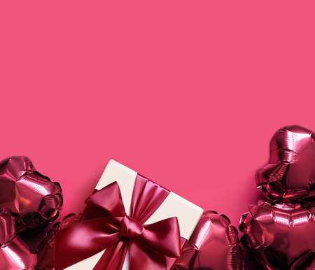 Top view photo of valentine's day decorations. White gift box with red ribbon bow and air hearts on isolated red background with empty space.の写真素材
