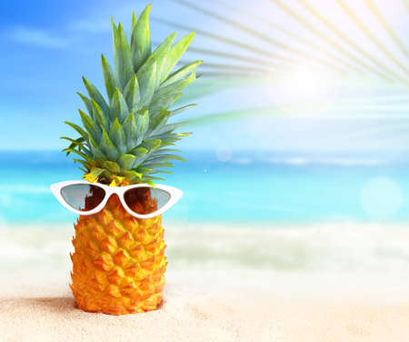 Pineapple with sunglasses on tropical beach background. summer concept.の写真素材