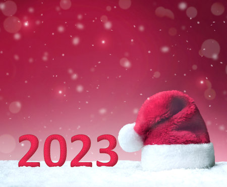 Numbers 2023 with red Santa hat on red glittering background on snow. copy spaceの写真素材