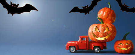 Truck loaded with many beautiful orange pumpkins and bats. Preparing for the scary Halloween holidayの写真素材