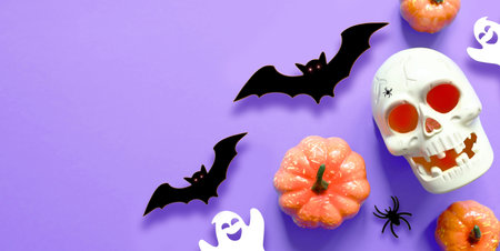 Halloween decorations on purple background. Happy Halloween concept. Flat lay pumpkins, scull, bats, ghosts and spidersの写真素材