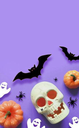 Halloween decorations on purple background. Happy Halloween concept. Flat lay pumpkins, scull, bats, ghosts and spidersの写真素材