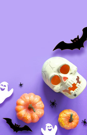 Halloween decorations on purple background. Happy Halloween concept. Flat lay pumpkins, scull, bats, ghosts and spidersの写真素材