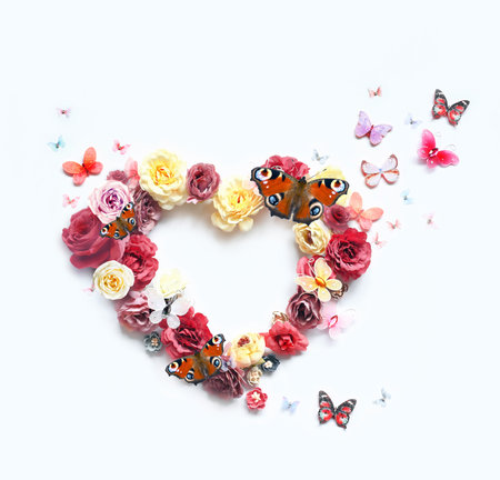 Happy mothers and Valentines day. Bouquet of colorful assorted roses in heart shape and butterfly on white background. holiday concept.の写真素材