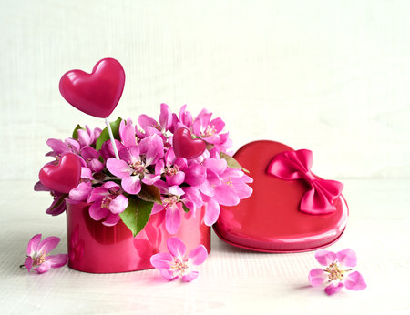 Valentines Day. Pink flowers in a red box in the form of a heart on a white background. The concept of delivering flowers. floristry and flower shops.の写真素材