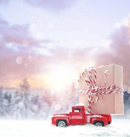 Christmas background with snow and retro car with gift box. Merry Christmas and happy New Year.の写真素材